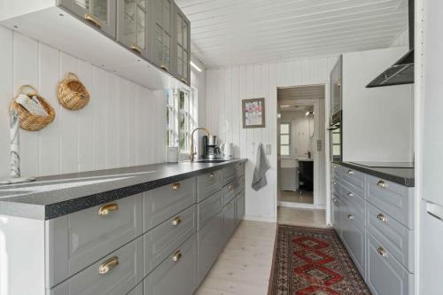 a kitchen with blue cabinets and a counter top at Charming Cottage Close To The Beach in Glesborg