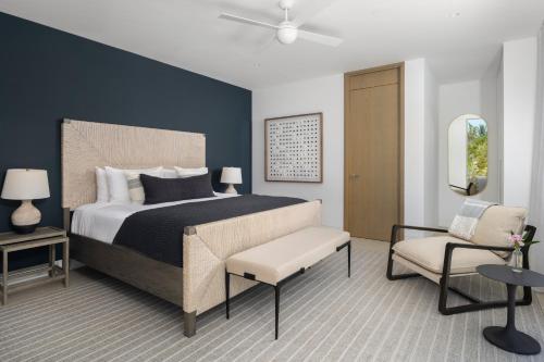 a bedroom with a large bed and a chair at South Bank in Long Bay Hills