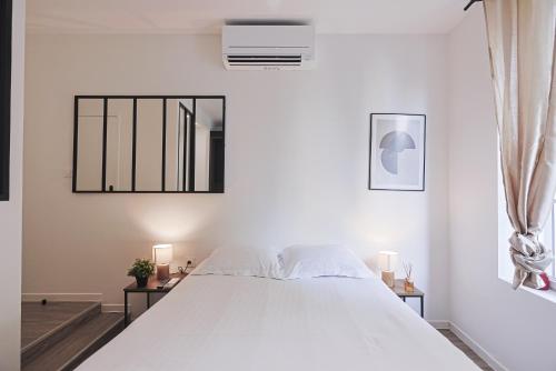 a white bedroom with a large bed and a window at LES BULLES DE MONA - Passion - Spa - Clim in Lyon