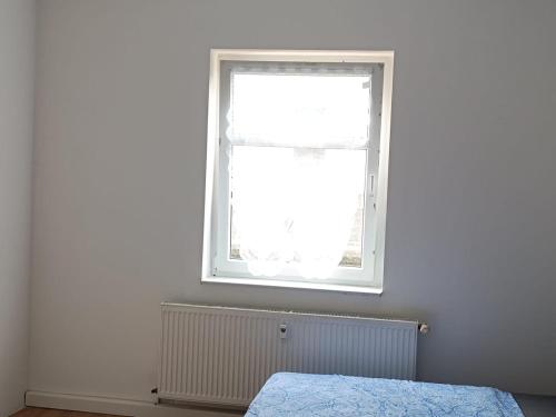 a bedroom with a bed and a window at Large flat with separate rooms for 8 guests ST0 in Zeitz