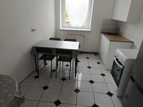 a kitchen with a table and four chairs on a tiled floor at Large flat with separate rooms for 8 guests ST0 in Zeitz