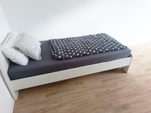 a bed with a black and white sheets and pillows at Large flat with separate rooms for 8 guests ST0 in Zeitz
