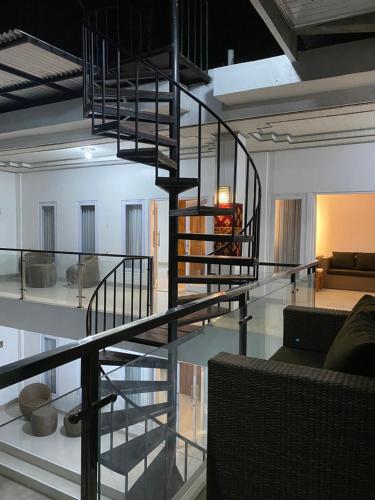a spiral staircase in a room with a living room at SR Buming House in Toyapakeh
