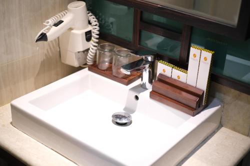 a bathroom sink with a mixer on top of it at Grand Sya Hotel in Palu