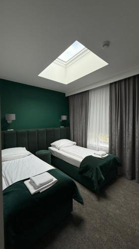 a hotel room with two beds and a skylight at Stara Biblioteka in Wrocław