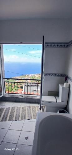 a bathroom with a tub and a view of the ocean at ARTIST HOUSE Rooms With View And Shared Kitchen in Arco da Calheta