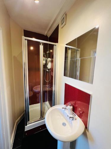 a bathroom with a white sink and a shower at Thistle Residence in Edinburgh