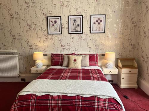 a bedroom with a bed with two night stands and two lamps at Thistle Residence in Edinburgh