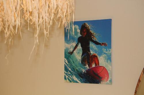 a painting of a woman riding a wave on a surfboard at auberge Brava Tifnit 