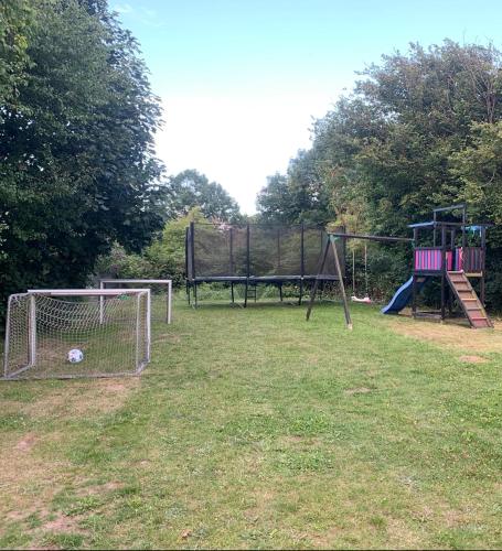 a park with two swings and a goal at Lækker lejlighed med lille have in Bogø By