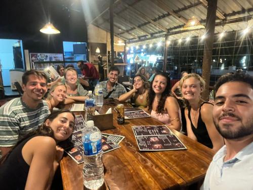 a group of people sitting around a wooden table at Wave Loom Hostel Ahangama in Ahangama