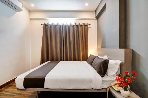 a bedroom with a white bed with a curtain at Townhouse Ecity Inn in Bengaluru