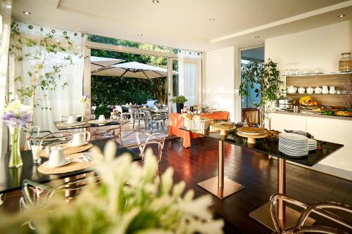 un restaurant avec des tables et des chaises dans une salle dans l'établissement Hôtel Les Jardins, à Lucciana