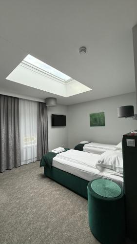 a hotel room with two beds and a skylight at Stara Biblioteka in Wrocław