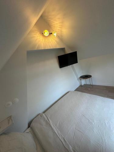a small bedroom with a bed with a light on the wall at Studio Proche Gare, Centre ville in Agneaux