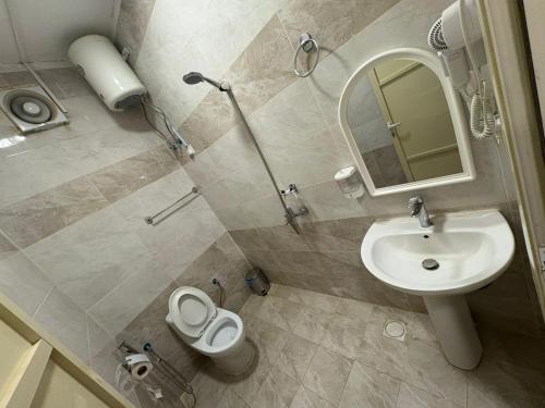 ein Badezimmer mit Waschbecken, Toilette und Spiegel in der Unterkunft لؤلؤة الثريا للشقق المخدومة فرع العقيق in Riad