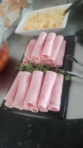 a plate of food with pink meat on a table at Pousada La pasta beach in Valença