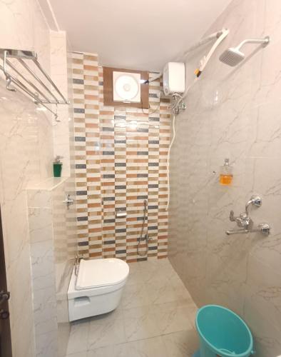 a white bathroom with a toilet and a shower at Kashi V Homestay in Varanasi