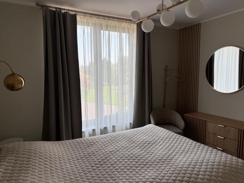 a bedroom with a bed and a large window at Lauras in Bauska