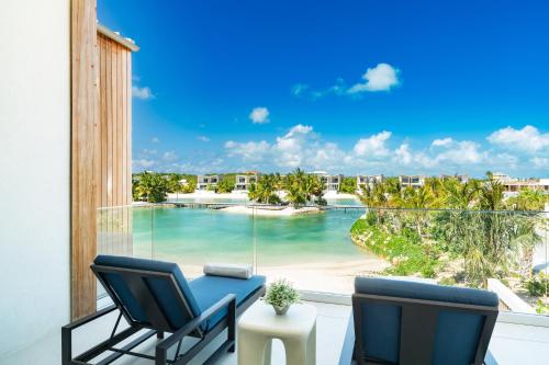 a balcony with two chairs and a view of a beach at South Bank in Long Bay Hills