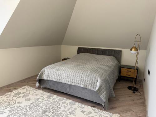 a bedroom with a bed and a lamp and a rug at Lauras in Bauska