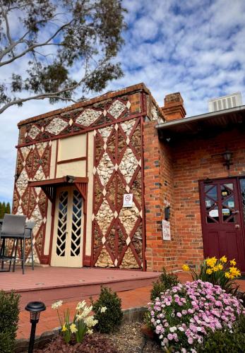 a brick building with a gate and flowers at Diamond House Motor Inn in Stawell