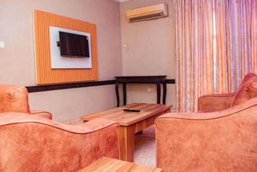 a room with two chairs and a table and a television at Dees Hotels Apartments And Suites in Lagos