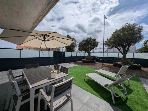 a patio with a table and chairs and an umbrella at Apartamentos Aurea - Porto Santo in Porto Santo