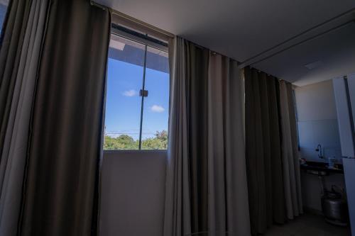 a room with a large window with curtains at Flats Regamar in Porto De Galinhas