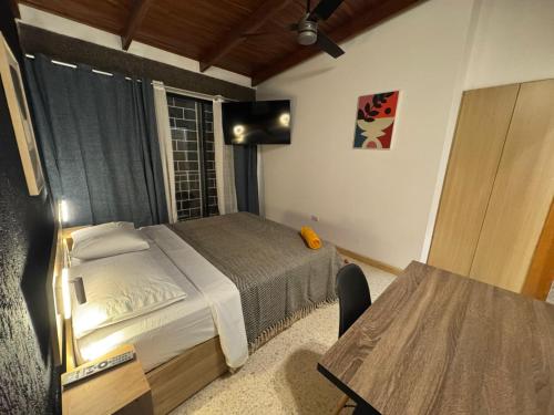 a small bedroom with a bed and a table at Jungla Urbana, BnB in Pavas