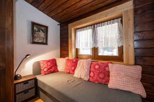 a bedroom with a bed with pillows and a window at Cosy Cottage in Vyšná Boca in Vyšná Boca