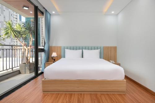 a bedroom with a bed and a balcony at Hummer Hotel & Apartment Da Nang Beach in Da Nang