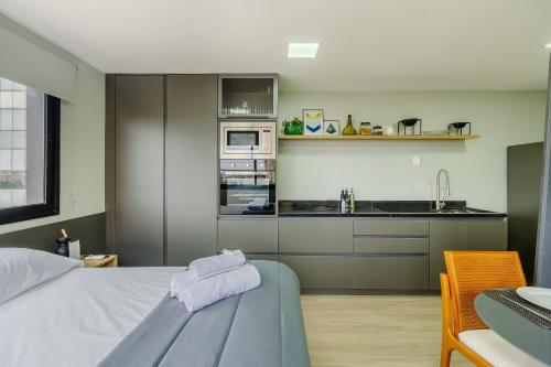 a bedroom with a bed and a kitchen at Novíssimo: Go Carlos Gomes - Infra estrutura e Vista Espetacular! in Porto Alegre