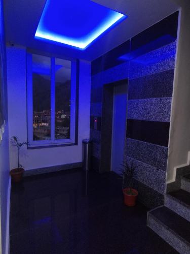 a blue room with a window and a blue ceiling at Aliza Inn And Suites By SRS Hotels in Dharamshala