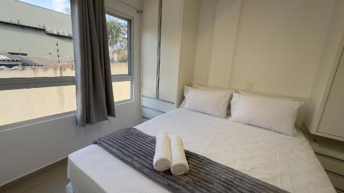 a bedroom with a bed with two white towels on it at Lindo e confortável apartamento no Centro de Foz in Foz do Iguaçu