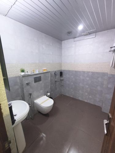 a bathroom with a toilet and a sink at Aliza Inn And Suites By SRS Hotels in Dharamshala