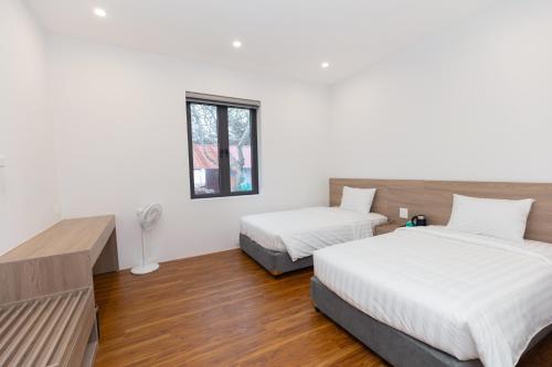 a bedroom with two beds and a window at Villa Sea in Trà Cổ