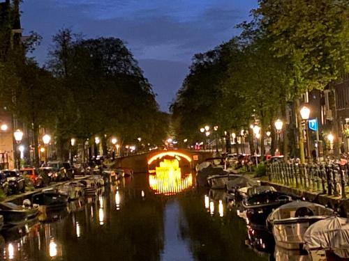 un canal avec des bateaux dans une ville la nuit dans l'établissement JoyJoyJoy the White Wilde ecolicious studio in a historic Canalhouse from 1799 with terrace at the canals, à Amsterdam