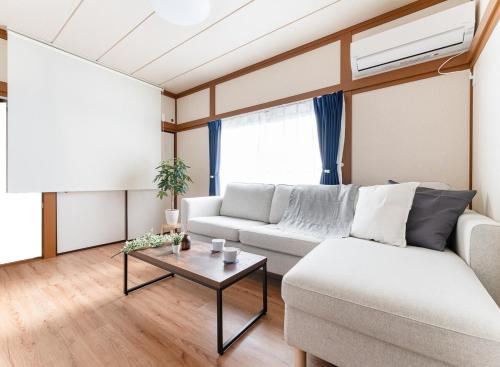 a living room with a couch and a table at Kasai Hotel near Shinjuku, Akihabara, Asakusa TDR-Disney T-LAB 一棟まるまる葛西ホテル最大9名 in Tokyo