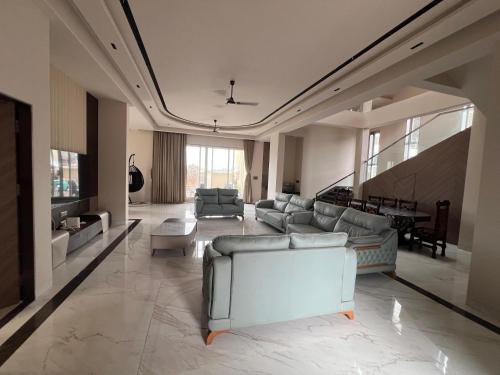 a large living room with couches and a piano at Royal Elite - 6BHK Luxury Villa by Royal Villa Lonavla in Lonavala