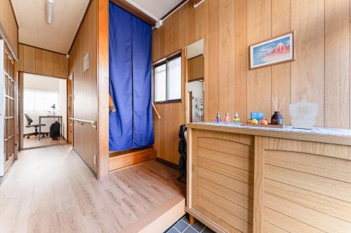 a room with wood paneled walls and a bar with blue curtains at Kasai Hotel near Shinjuku, Akihabara, Asakusa TDR-Disney T-LAB 一棟まるまる葛西ホテル最大9名 in Tokyo
