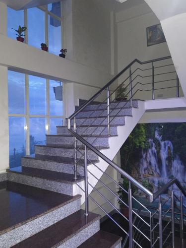 a staircase in a house with a mural on the wall at Aliza Inn And Suites By SRS Hotels in Dharamshala