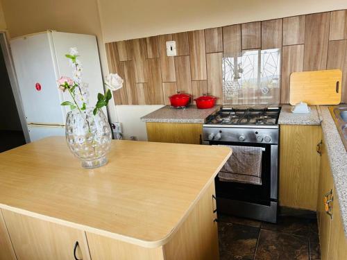 a kitchen with a vase of flowers on a counter at Bird & Bed Farmhouse in Brits