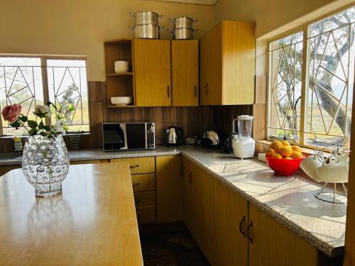a kitchen with a vase of flowers on a counter at Bird & Bed Farmhouse in Brits