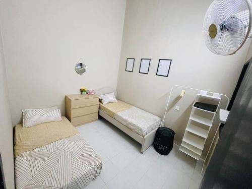 a small room with two beds and a fan at Glamstay Jitra Suasana Permai in Jitra