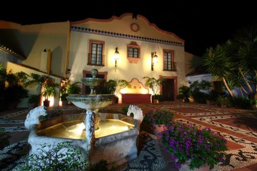 een groot huis met een fontein ervoor bij Cortijo De Cortes in Estepona