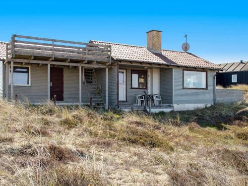 a house sitting on top of a grass covered field at 6 person holiday home in Henne-By Traum in Henne Strand