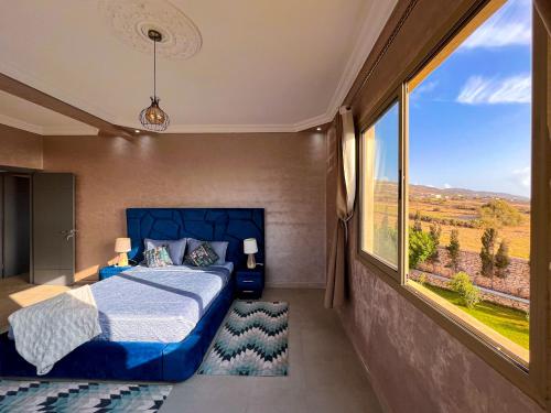 a bedroom with a bed and a large window at Villa MLY Bouzerktoun in Essaouira