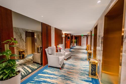 a corridor of a hotel lobby with chairs and plants at Grand Plaza Badr Al Maqam Fully Renovated in Al Madinah