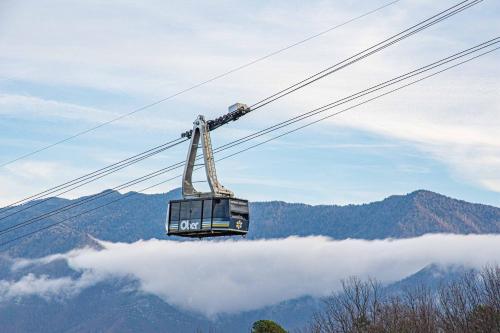 a gondola is flying above the clouds in the mountains at Ober Lux Chalet in Gatlinburg